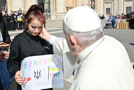 Pope Francis greets a girl while meeting with a group of Ukrainians after his weekly general audience in St. Peter's Square at the Vatican April 27, 2022. She was one of 11 orphaned children who escaped Ukraine and found assistance in early March from an Italian Catholic organization.