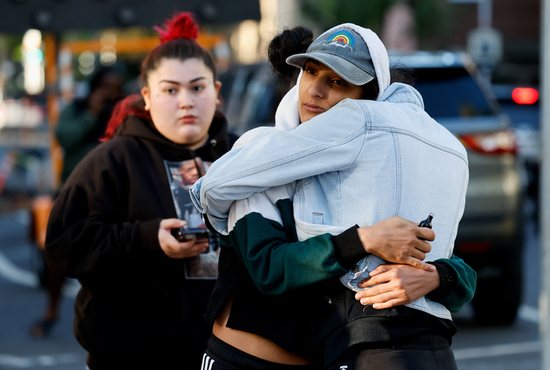 People in Sacramento, Calif., hug near the crime scene after an early-morning shooting in a stretch of downtown near the Golden 1 Center arena April 3, 2022. At least six people were killed and at least 12 were wounded as people were leaving nightclubs, authorities said. Gunfire reportedly erupted just after a fight broke out on the street, but police said they did not know if the altercation was connected to the shooting.