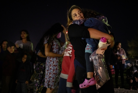 Cynthia, a migrant from Honduras seeking asylum in the U.S., holds a bottle of baby formula for her 3-year-old daughter, Alicia, as she waits to board a bus to a U.S. Customs and Border Protection facility in Roma, Texas, May 13, 2022.
