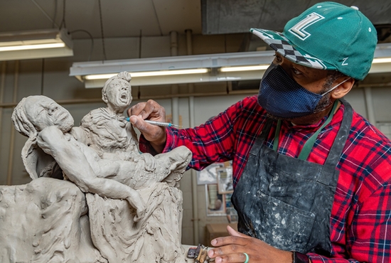Wayman Scott IV, a parishioner of the Church of the Nativity in Timonium, Md., works on his Pietà sculpture, which features African American figures.