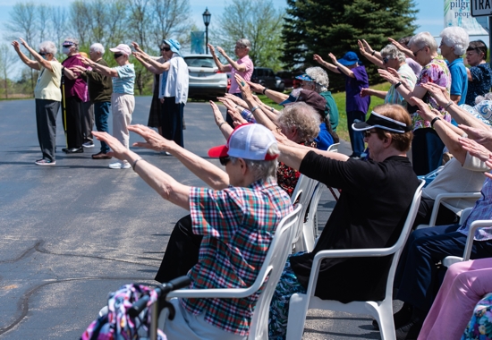 Members of the Sisters of St. Francis of the Holy Cross in Green Bay, Wis., raise their arms May 14, 2022, during the blessing of a monument with a plaque that acknowledges "the First Nations people who are the original inhabitants of this region." The Green Bay Franciscans are the first known community of women religious in Wisconsin to issue a land acknowledgment policy. 