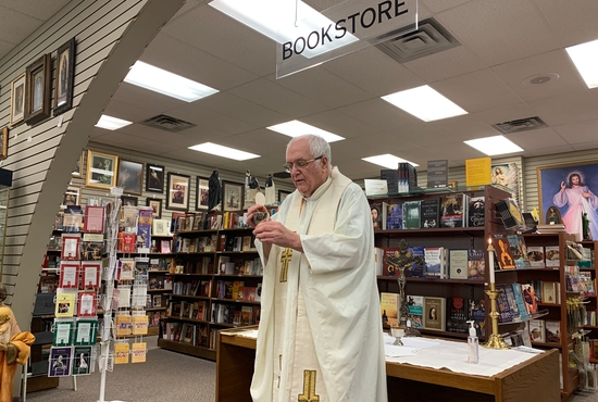 Father Dennis Evenson celebrates Mass inside the Leaflet Missal religious goods store in St. Paul.