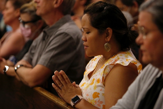 People pray and grieve during Mass at Immaculate Conception Church in Highland Park, Ill., July 5, 2020, one day after a mass shooter killed seven people and injured at least 30 people during the community's Independence Day parade.