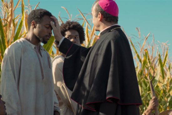 St. Anthony Mary Claret (played by Antonio Reyes) blesses Lucas (Joseph Ewonder), a slave, in “Slaves and Kings.” (Stellarum Films)