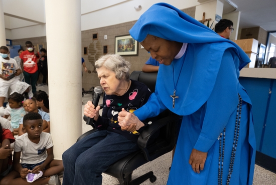 Mary Jo prays at the start of a weekly gathering with residents Aug. 18.