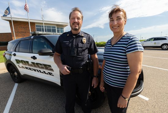 From left, Commander Jim Puncochar of the Lakeville Police Department stands outside of the police station with Ruth Laursen, who brought St. Michael medals to him in 2016 for distribution to his officers and staff. 