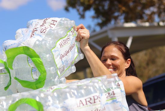 Melissa Stevens helps with distributing water and emergency supplies at the Elizabeth Kay Galeana Catholic Charities Center in Fort Myers, Fla., Oct. 4, 2022, amid the aftermath of Hurricane Ian.