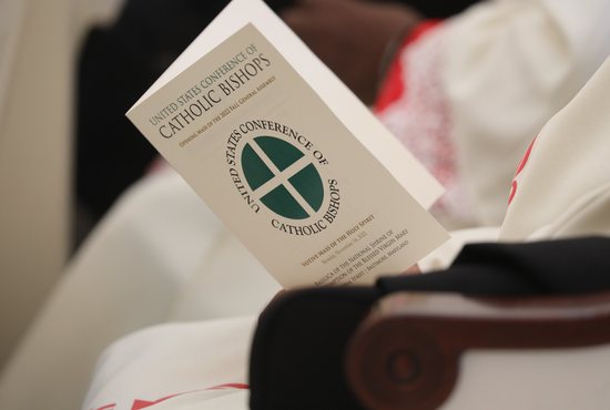 A bishop holds a program during Mass at the Basilica of the National Shrine of the Assumption of the Blessed Virgin Mary Nov. 14, 2022, on the first day of the fall general assembly of the U.S. Conference of Catholic Bishops in Baltimore.