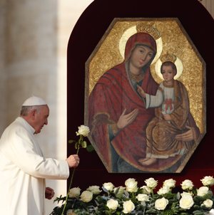 Pope Francis presents a rose at an icon of Mary and the child Jesus as he begins his general audience in St. Peter's Square at the Vatican Dec. 9, 2015. A rose symbolizes Mary in the old German hymn, "Lo How A Rose E'er Blooming."