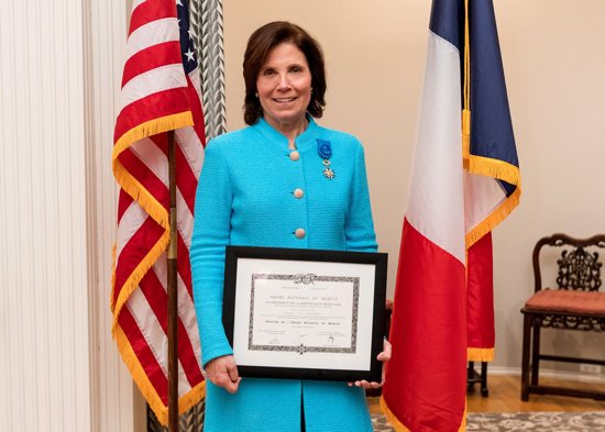 Carla Knorowski, center, is awarded the rank of officer in France's National Order of Merit for her efforts to raise funds to restore Notre-Dame Cathedral in Paris during a ceremony in Chicago Oct. 8, 2022. She joined the board of directors of the Friends of Notre-Dame de Paris in 2019. 