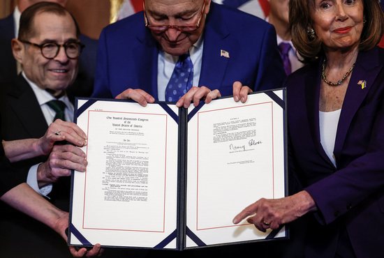 Rep. Jerry Nadler D-N.Y., left, Senate Majority Leader Chuck Schumer, D-N.Y., and House Speaker Nancy Pelosi, D-Calif., hold the Respect for Marriage Act during a bill enrollment ceremony on Capitol Hill in Washington Dec. 8, 2022.