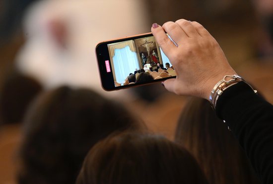Pope Francis is pictured on a cell phone as he leads an audience with children from Italy's Catholic Action organization at the Vatican Dec. 15, 2022. The pope encouraged kids to put down their phones in order to gaze at God and care for others.