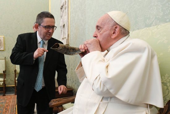 Pope Francis blows into a shofar presented by Rabbi Ariel Stofenmacher, rector of the Latin American Rabbinical Seminary, during an audience with a delegation from the seminary at the Vatican Dec. 2, 2022.