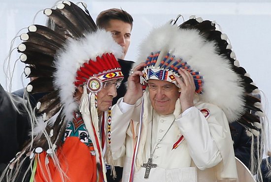 Pope Francis adjusts a traditional Indigenous headdress during a meeting with First Nations, Métis and Inuit communities at Maskwacis, Alberta, July 25, 2022.
