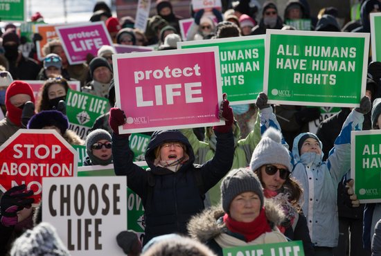 Participants hold signs at the State Capitol during last year’s annual MCCL March for Life Jan. 22. This year will feature a Mass and prayer service at the Cathedral of St. Paul in St. Paul, followed by the march.