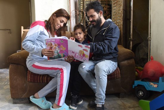 Parents are pictured in a file photo reading to their daughter. Before Google and especially before AI, there were these things called parents, and children would go to them with questions, and things like conversations and learning and families would be built upon them.