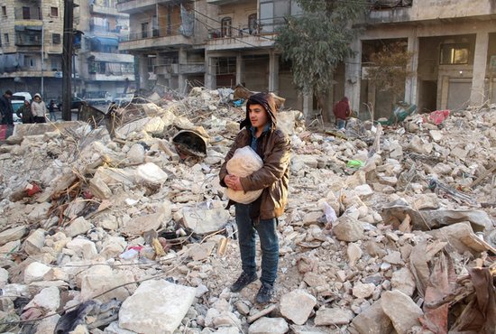 A young earthquake survivor stands amid the debris of a destroyed building in Aleppo, Syria, Feb. 7, 2023. Aleppo, devastated after the horrendous earthquake that struck the morning of Feb. 6, is trying to pick up the pieces after the shock of the catastrophe. Local bishops are calling the situation "desperate" and the earthquake itself "biggest terror."