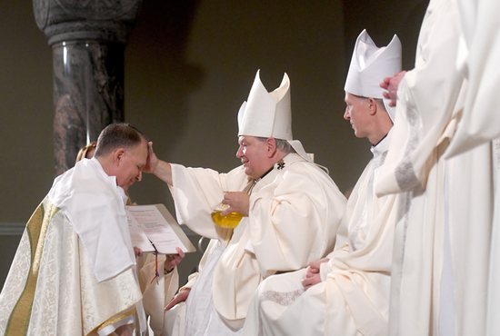 Archbishop Bernard A. Hebda of St. Paul and Minneapolis rubs sacred chrism oil on the head of Bishop Patrick M. Neary during his episcopal ordination at St. Mary's Cathedral in St. Cloud, Minn., Feb. 14, 2023. Bishop Neary was ordained and installed as the 10th bishop of the Diocese of St. Cloud. 