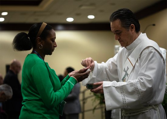 A woman receives Communion during the sending Mass of the Catholic Social Ministry Gathering in Washington D.C., Jan. 31, 2023.