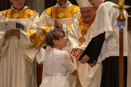 Terhaar states the Renewal of Intention, offering herself to God as she offers her hands to Archbishop Bernard Hebda of the Archdiocese of St. Paul and Minneapolis. Each candidate at the Mass knelt and said, “Father, receive my resolution to follow Christ in a life of perfect chastity which, with God’s help, I profess before you and God’s holy people.”