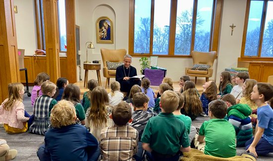 Bishop Michael Izen reads the Gospel of John to second graders in their Catechesis of the Good Shepherd class April 14 in the library at St. Croix Catholic School in Stillwater. The students are preparing for their first sacrament of reconciliation and reception of holy Communion.