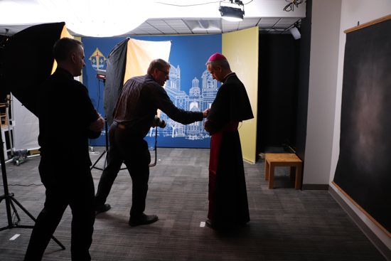 Bishop-elect Michael Izen gets ready to have his official portraits taken March 16 by Dave Hrbacek, center, staff photographer at The Catholic Spirit. At left is Bishop Joseph Williams, who helped with the photo shoot.