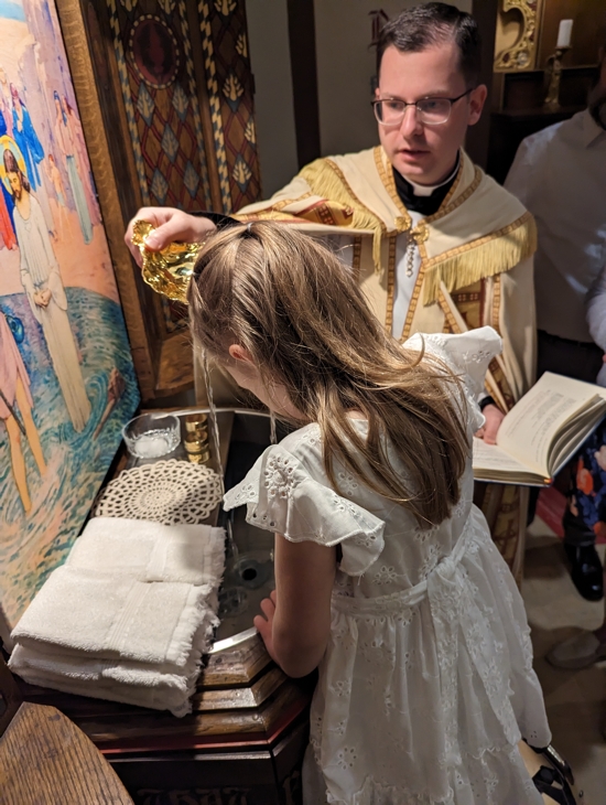 Hollis Norman, 5, receives the waters of baptism April 15 from Pro Ecclesia Sancta Father Joe Barron, associate pastor of St. Mark in St. Paul. Hollis is among five children from three families who were baptized in the same ceremony, inspired along with their parents by the staff at St. Mark’s Preschool.
