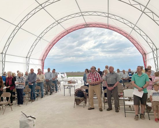 Worshippers pray in the hoop barn on the Pieper family farm in Donnellson, Iowa, during a Mass for the farm and the blessing of seeds April 15, 2023. Father Dan Dorau celebrated the Mass, whose inspiration comes from Catholic Rural Life. The four parishes he leads in Lee and Van Buren counties collaborated. 