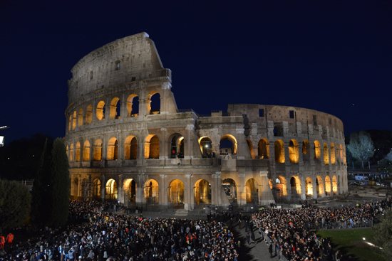 Crowds gather at Rome's Colosseum for the nighttime Way of the Cross service on Good Friday, April 7, 2023. The Vatican announced Pope Francis would not attend the event as planned because of the cold.