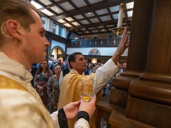 Father Jonathan Kelly, rector of St. John Vianney College Seminary in St. Paul, anoints the walls of the new chapel during the dedication Mass April 20.