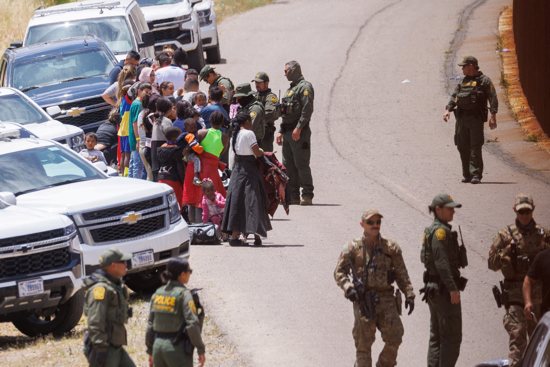U.S. Border Patrol agents organize a group of families between primary and secondary border fences near San Diego May 9, 2023. Large numbers of migrants gathered at the border as the United States prepared to lift COVID-19 era Title 42 restrictions that have blocked migrants at the U.S.-Mexico border from seeking asylum since 2020.