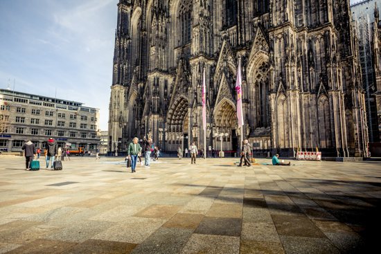 People walk outside the cathedral in Cologne, Germany, March 16, 2020. Germany's Catholic church will be forced to give up a third of its properties in the face of dwindling membership and revenue, according to a new report, with many facing demolition unless converted to other uses.