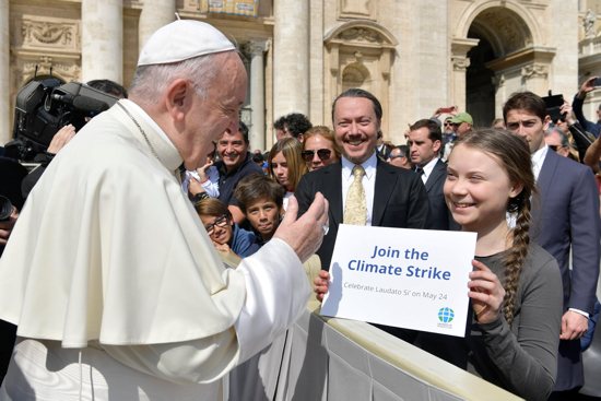 Pope Francis greets Swedish climate activist Greta Thunberg during his general audience in St. Peter's Square at the Vatican in this file photo from April 17, 2019. In a new book, Pope Francis writes that people must learn from young people to care for the poor and for the environment.
