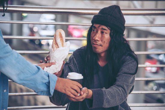 Woman helping hands to homeless people