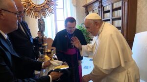 Pope Francis blesses a four-foot-tall monstrance, a chalice and a paten as Bishop Andrew H. Cozzens of Crookston, Minn., looks on during an audience in the library of the Apostolic Palace June 19, 2023. The blessing took place during the pope's meeting with members of the organizing committees of the U.S. National Eucharistic Congress and Eucharistic Revival. 