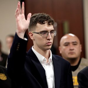 Walmart mass shooter Patrick Crusius raises his hand during his arraignment in El Paso, Texas, Oct. 10, 2019. Crusius, now 24, who fatally shot 23 people at a Walmart store in El Paso in a targeted attack against people of Mexican descent, was sentenced July 7, 2023, to 90 consecutive life terms following two days of gut-wrenching testimony from survivors and relatives of victims of that massacre.