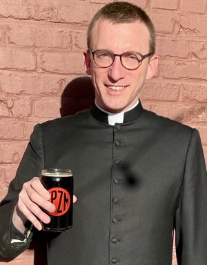 Father Brian Capuano, a priest of the Diocese of Richmond, Va., poses with "Father Brian's Bourbon Barrel Brown Ale," his own recipe released by Trapezium Brewing Company in Petersburg, Va.