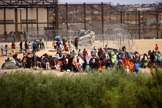 Migrants, mostly from Venezuela, are seen seen from Ciudad Juarez, Mexico, as they gather near the U.S. border wall Sept. 24, 2023, after crossing the Rio Grande with the intention of turning themselves in to the U.S. Border Patrol agents to request asylum.