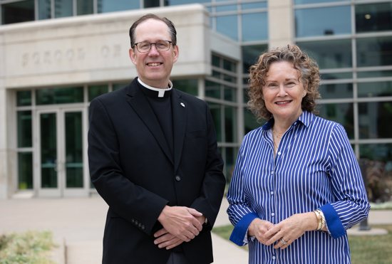 Father Daniel Griffith and Julie Craven stand outside the University of St. Thomas School of Law. Father Griffith is the founding director of the Initiative on Restorative Justice and Healing, and Craven is its associate director.