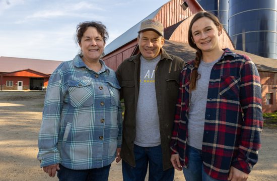 Standing near the barns of their dairy farm near Rogers are from left, Staci and John Scherber and their daughter, Qunci Schmidt.