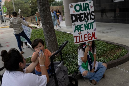 Deferred Action for Childhood Arrivals policy recipient provides water to her one year old son next to another recipient who holds a placard ahead of a hearing on the DACA program outside the federal courthouse in Houston, Texas, U.S., June 1, 2023. A federal judge in Texas ruled Sept. 13 that Biden's version of DACA is illegal but keeps the program in place for current immigrant recipients.