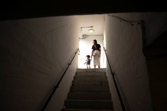 An Israeli woman holds the hand of an infant at the entrance to a bomb shelter as rockets from Gaza are launched towards Israel in Ashkelon, southern Israel October 8, 2023.
