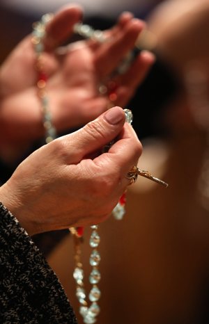 A woman prays the rosary during Eucharistic adoration following the opening Mass of the National Prayer Vigil for Life Jan. 19, 2023, at the Basilica of the National Shrine of the Immaculate Conception in Washington.