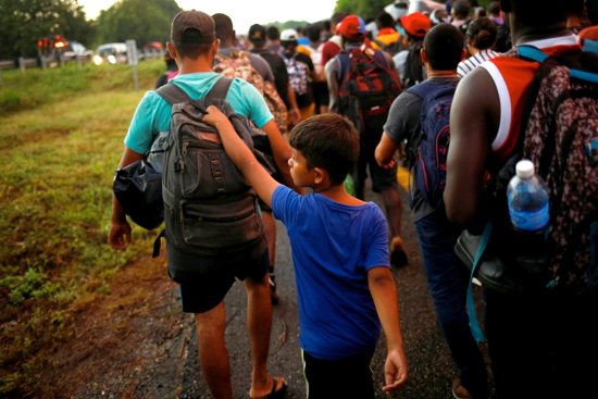 A young migrant from Venezuela walks with his brother as they join a caravan near Villa Comaltitlán, Mexico, heading to the U.S. border Nov. 20, 2021.