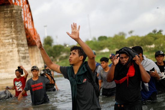 A Venezuelan migrant is seen from Piedras Negras, Mexico, Sept. 30, 2023, as he thanks God while walking through the Rio Grande in an attempt to cross into Texas to seek asylum in the United States.