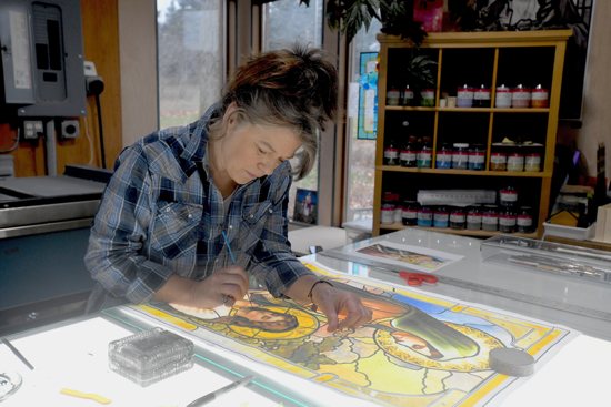 Minnesota stained-glass artist Christi Becker works on a stained-glass window in her studio in this undated photo.