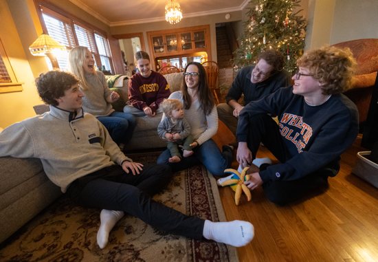 Adrienne Hollis, center, holds her son, Vladislav Cook, while surrounded by, clockwise from lower left, Owen, Sarah, Lucy, David and Josiah Hoffner in their south Minneapolis home Jan. 3. The Hoffners have been providing foster care for Cook through a program called Together for Good, a St. Paul-based organization that, according to its website, offers services like foster care to provide “practical help and relational support for parents and their children.”