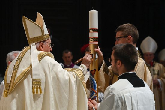 Pope Francis inscribes a cross on the Paschal candle at the beginning of the Easter Vigil Mass in St. Peter's Basilica at the Vatican April 8, 2023.