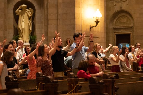 People raise their hands in prayer during a special prayer service after the Extended Vigil of Pentecost May 18 at the Cathedral of St. Paul in St. Paul.