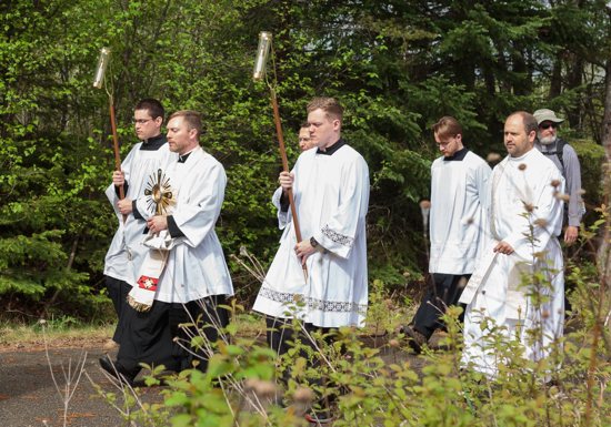 Seminarian Mason Bailey, center holding a candle, and other pilgrims, process from St. Theodore's Catholic Church in Laporte, Minn., along the Paul Bunyan State Trail during the National Eucharistic Pilgrimage May 20, 2024. Bailey, 24, is one of seven seminarians who are traveling the four routes of the National Eucharistic Pilgrimage, which began in California, Connecticut, Minnesota and Texas May 18-19 and converges in Indianapolis for the National Eucharistic Congress July 17-21.